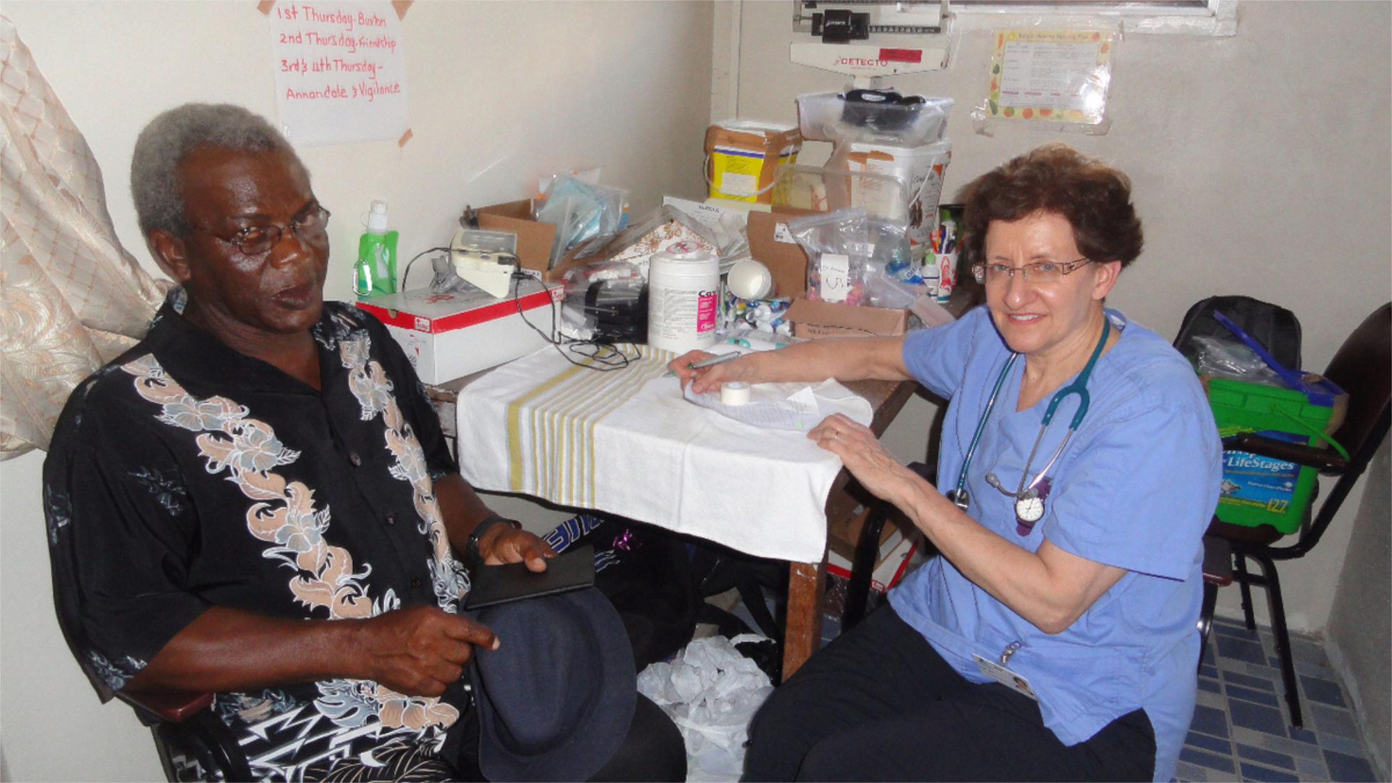 Nurse sitting at a nursing station with a patient